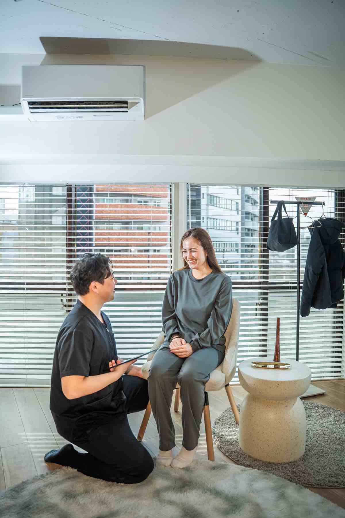 窓のある店内で姿勢を確認する施術者